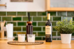 Eine Flasche Wein und zwei Gläser auf einem Tisch in der Unterkunft MOLA Apartments-Stilvolle Altstadtwohnung- Seilersee-5 Personen-Terrasse-Grill-Gratis WLAN in Iserlohn