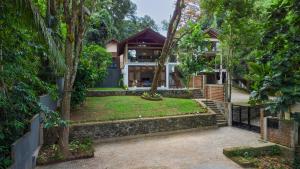 an exterior view of a house with trees at Tropical Grove in Polgolla