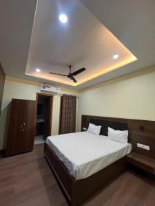 a bedroom with a bed with a ceiling fan at Oasis hotels in Hoshiārpur +9 photos