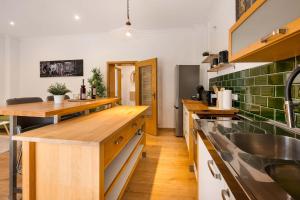 Eine Küche mit Holzarbeitsplatten und grünen Fliesen in der Unterkunft MOLA Apartments-Stilvolle Altstadtwohnung- Seilersee-5 Personen-Terrasse-Grill-Gratis WLAN in Iserlohn + 40 Fotos