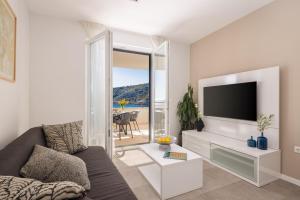 a living room with a couch and a flat screen tv at Villa Lavanda Deluxe in Rogoznica
