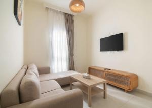 a living room with a couch and a tv at The Avenue in El Alamein
