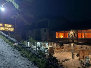 a building with a clock on it at night at Granny's Den - Nathia Gali in Nathia Gali