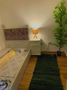 a bedroom with a bed and a lamp and a plant at Adel home in Kafr al Ishārah