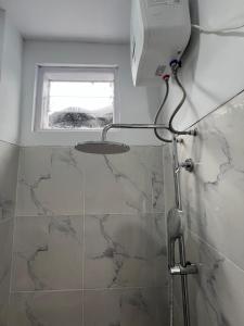 a shower in a bathroom with a window at hb co living in Tanjungredep