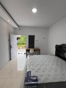 a bedroom with a bed and a desk and a television at hb co living in Tanjungredep