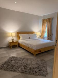 a bedroom with a bed and two lamps and a rug at Granny's Den - Nathia Gali in Nathia Gali +6 photos