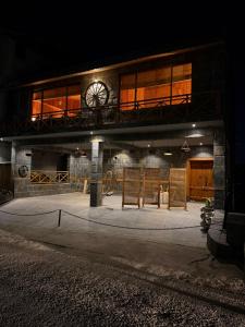 a building with a clock on top of it at night at Granny's Den - Nathia Gali in Nathia Gali