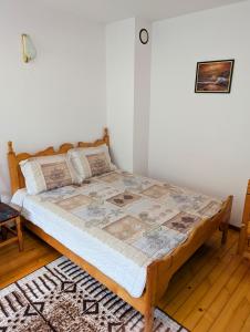a bed in a bedroom with a wooden floor at Апартамент Извор 6 in Smolyan