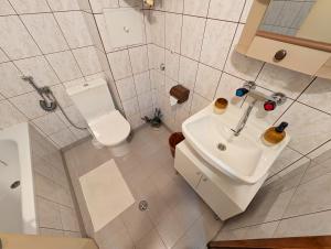 a bathroom with a white toilet and a sink at Апартамент Извор 6 in Smolyan +5 photos