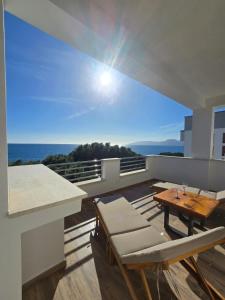 a room with a balcony with a table and chairs at Blue Bay rooms in Cala Gonone