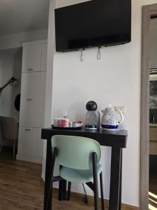 a table with a chair and a television on a wall at Blue Bay rooms in Cala Gonone