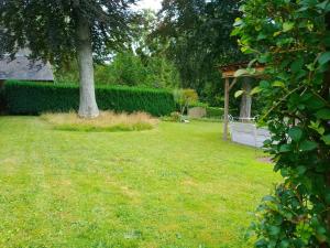 a yard with a tree and a gazebo at Karibu Normandy in Saint-Désir