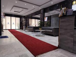 a lobby with a red carpet and couches and a red rug at KA Hôtel Dely Ibrahim in Deli Ibrahim