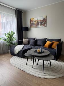 a living room with a couch and a table at Golden corner in Plungė