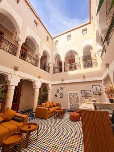 a living room with couches and tables in a building at Riad Zaki Marrakech in Marrakesh