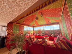 a living room with red couches and a colorful wall at Riad Zaki Marrakech in Marrakesh
