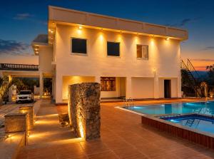 a villa with a swimming pool at night at Private Farm with Big Size Pool & 7 Rooms in Kukas in Jaipur