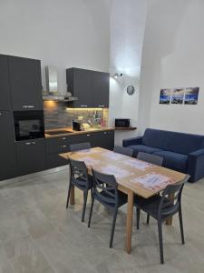 a kitchen with a table and chairs and a couch at Casa Vacanza S Elia in Veglie