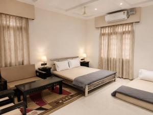 a bedroom with two beds and a couch at Private Farm with Big Size Pool & 7 Rooms in Kukas in Jaipur