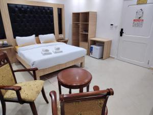 a bedroom with a bed and a chair and a door at KA Hôtel Dely Ibrahim in Deli Ibrahim