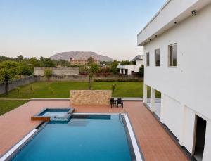a swimming pool in the backyard of a house at Private Farm with Big Size Pool & 7 Rooms in Kukas in Jaipur