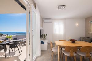 a dining room and living room with a table and chairs at Villa Lavanda Deluxe in Rogoznica