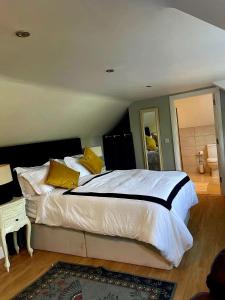 a bedroom with a large bed with yellow pillows at Dovetail Cottage in Wexford