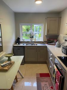 a kitchen with a table and a counter top at Dovetail Cottage in Wexford
