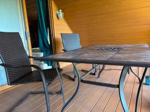 a wooden table and chairs on a porch at PrivateVillaHutamiLog in Nago +12 photos