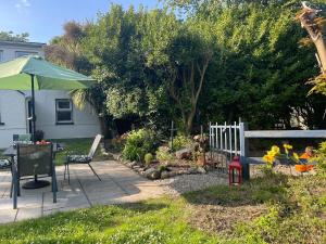 a garden with a bench and an umbrella at Dovetail Cottage in Wexford