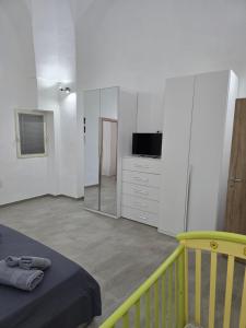 a bedroom with a bed and a tv and a mirror at Casa Vacanza S Elia in Veglie +8 photos