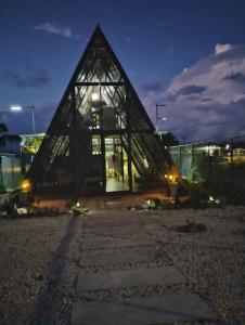 a large glass building with a pyramid shaped roof at A-frame cabin in Parrita