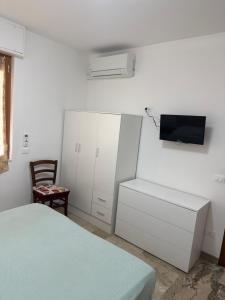 a bedroom with a bed and a tv on a wall at APPARTAMENTO MICKI 1 CAMERA e Soggiorno in Ventimiglia