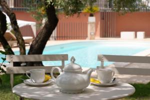 a tea pot and cups on a table near a pool at Villino con piscina in Terni