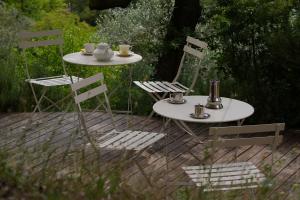 two tables and chairs with cups and mugs on them at Villino con piscina in Terni