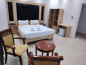 a bedroom with a bed and a chair at KA Hôtel Dely Ibrahim in Deli Ibrahim +10 photos