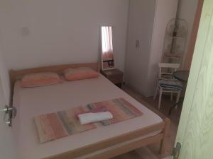 a small bedroom with two beds and a table at Apartman Sema in Donji Štoj