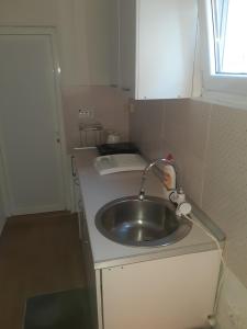 a small kitchen with a sink and a window at Apartman Sema in Donji Štoj