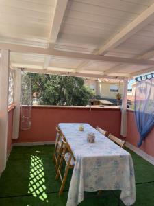 a table and chairs on a patio with a table and a window at Sweet Home Pia in La Maddalena +10 photos