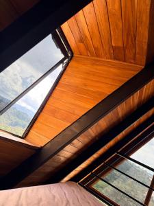 a bedroom with a wooden ceiling with two windows at Cabaña Con Jacuzzi Privado y Vista a La Montaña in Guarne