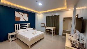 a bedroom with a bed and a tv in it at MBC Hotel in Guinlajong