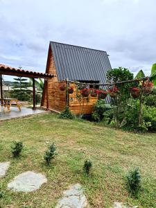 a small house with a garden and a pergola at Cabaña Con Jacuzzi Privado y Vista a La Montaña in Guarne