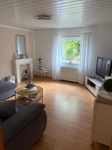 ein Wohnzimmer mit Sofa und Fernseher in der Unterkunft Weinstraße 2 in Höchstberg