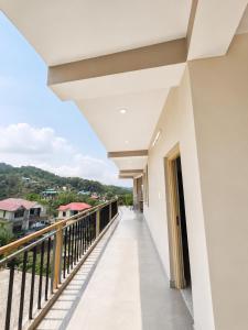 a balcony of a house with a view at Aurelia Ridge in Bīr