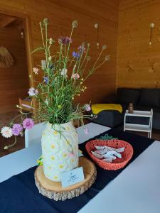 a large white vase with flowers in it on a table at Domki Sielankowo in Odargowo