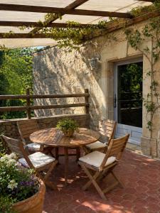 a patio with a table and two chairs and a table at Le Moulin des Salces in Saint-Privat