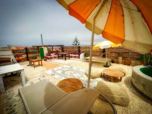 a patio with a table and an umbrella at Surf and Tribe in Tamraght Ouzdar