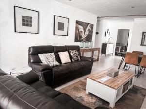 ein Wohnzimmer mit Ledersofa und einem Tisch in der Unterkunft Sunbirds Lodge Chobe in Kasane + 102 Fotos