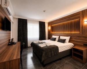 a bedroom with a large bed and a desk and a bed sidx sidx sidx sidx at Pamukkale Cleopatra in Pamukkale